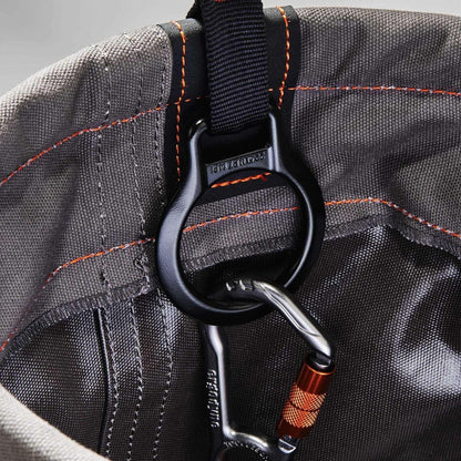 Close-up of a black tether D-ring at the gray canvas rim of the Ergodyne Arsenal 5960 hoist bucket, with a clip attached.
